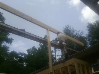Carpenter setting a ridge beam over a new addition frame — Ice Dam Removal by Roofing Brothers in Erwin