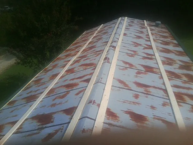 Rusted metal roof panels with new wood purlins before replacement — Storm Damage Roof Repair in Erwin by Roofing Brothers