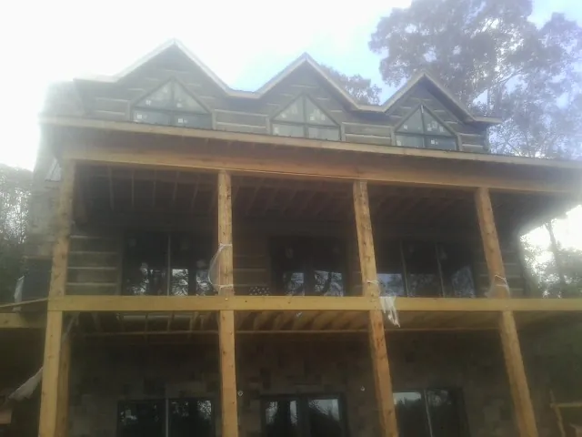 Dormers and porch framing on a large log home under construction — Roof Coating work by our crew in Erwin
