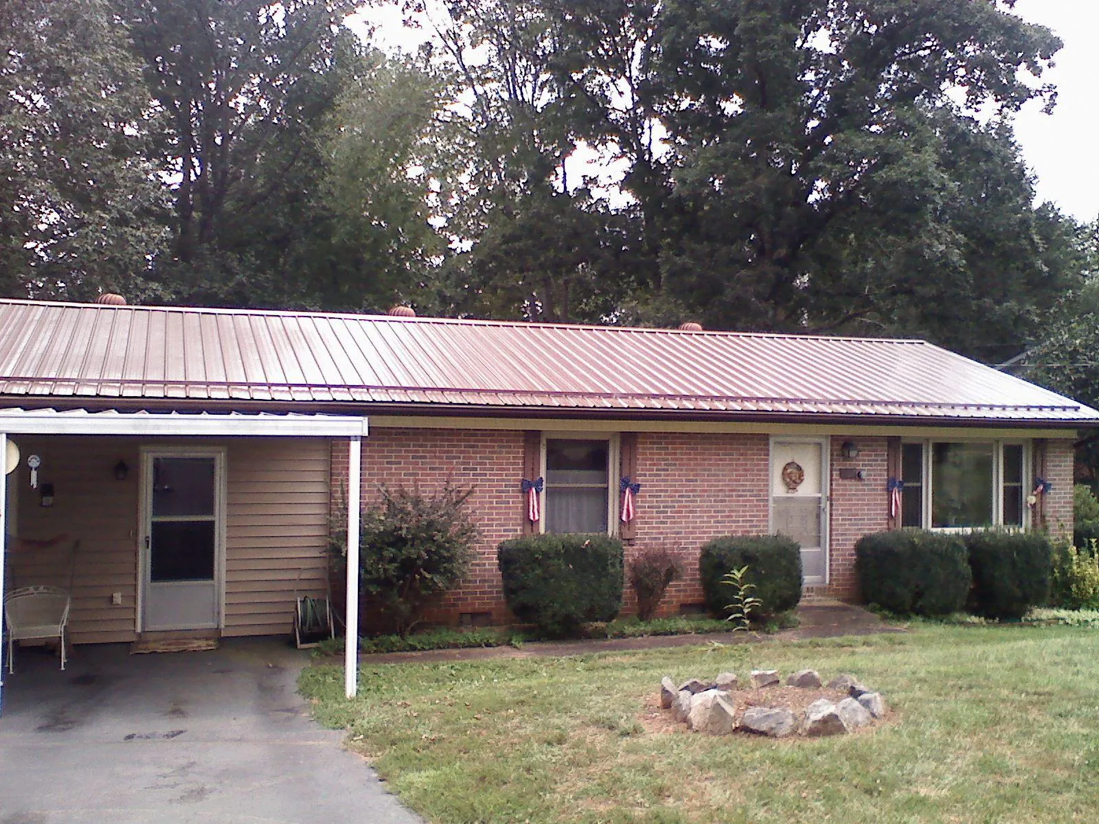 Bronze metal roof and carport on a brick ranch home — Roof Repair work by our crew in Erwin